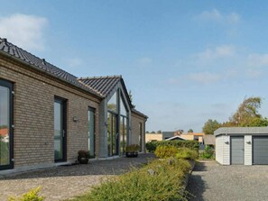 A modern building with a brick facade, large windows, and a gravel driveway. - 4 Star Holiday Home in Ebeltoft (Ebeltoft)