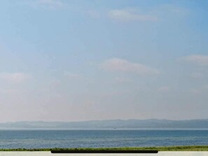 A coastal landscape with a clear sky, calm sea, and distant mountains. - 4 Star Holiday Home in Ebeltoft (Ebeltoft)