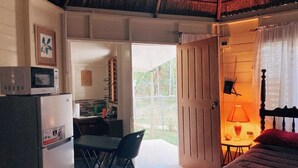 A compact room with a kitchenette, a dining area, and a bed.
