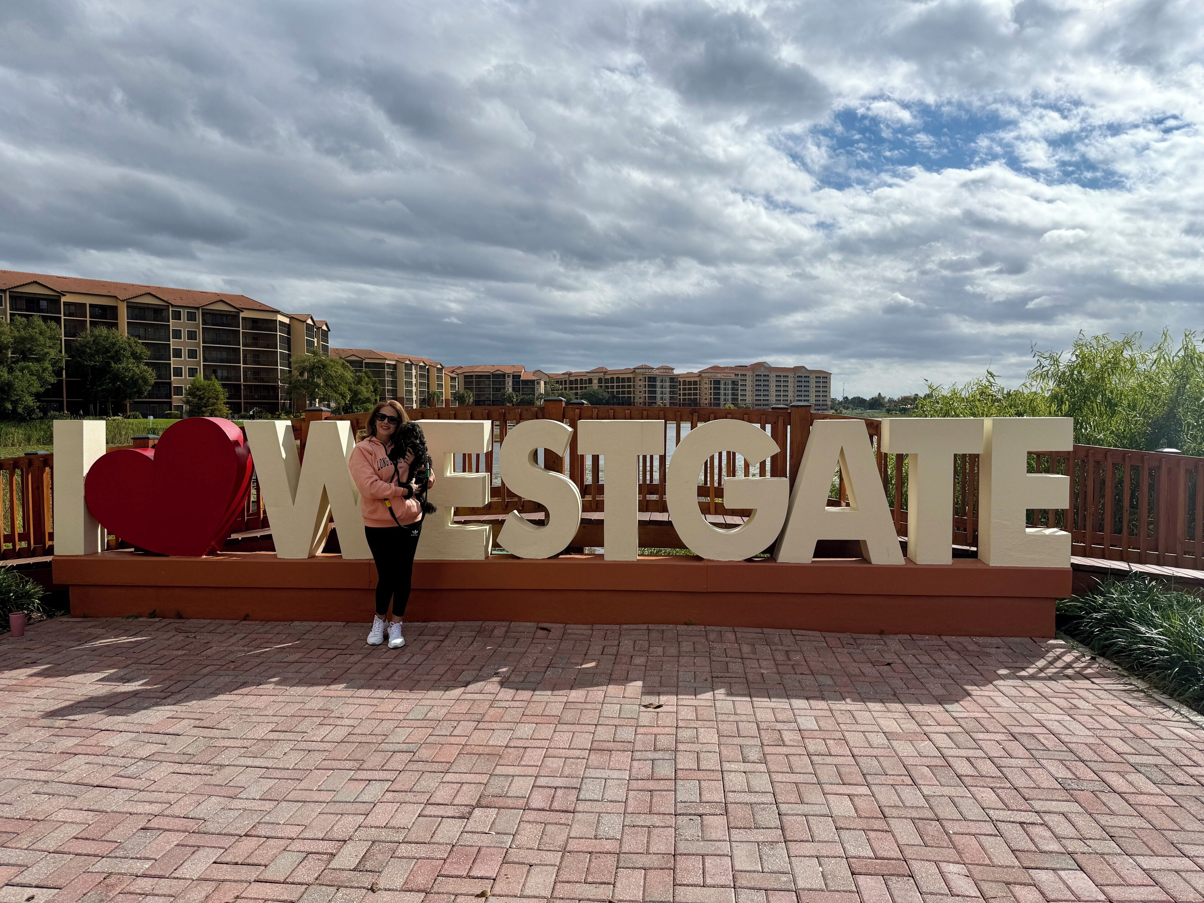 Una persona in piedi di fronte a un grande cartello con la scritta 'I LOVE WESTGATE' e un simbolo a forma di cuore.