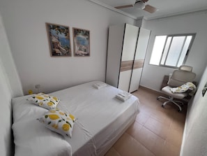 A bedroom with a bed, a desk, a chair, a wardrobe, and two paintings on the wall. - Bright apartment in Ruzafa near the Roig Arena and CAC | Sleeps up to 7 (1 bathroom) (València)