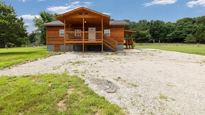 A wooden cabin with a balcony, a covered porch, and a gravel driveway. - Cloud Heaven Lodge. Close to Eureka Springs, 5 minutes to Eagle Rock Marina/TRL. (Holiday Island)