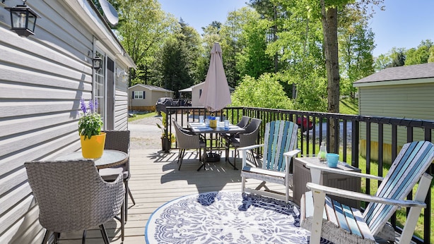 A deck with outdoor furniture, a dining table, and a potted plant.