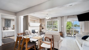 Un salon moderne comprenant un coin repas, un canapé, un téléviseur et un balcon avec vue.
