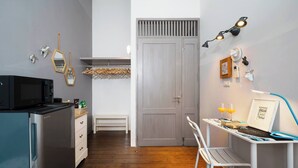 Cocina compacta con refrigerador, microondas y piso de madera.