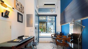 Una habitación con una mesa de comedor, sillas, un ventanal con vistas y una pared azul decorativa.