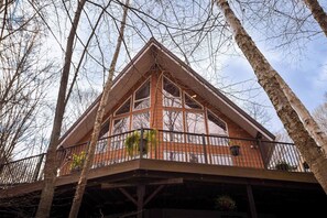 A wooden cabin with a balcony, surrounded by trees. - Rosseau Cathedral Grove (Rosseau)