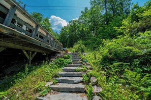 Eine Steintreppe führt einen Hügel hinauf, während sich daneben eine Bahngleis befindet.