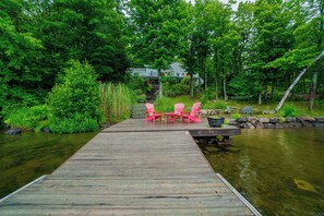 A wooden dock leading to a house surrounded by lush greenery. - Penn Lake Sweet Grass Ontario (Huntsville)