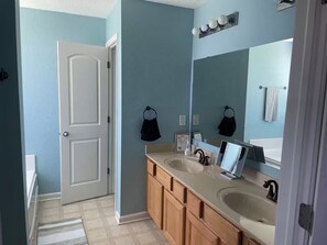 A bathroom with two sinks, a mirror, and a door leading to another room. - Rhodes comfort stay (Whitestown)