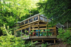 Eine mehrstufige Holzterrasse, umgeben von üppiger Vegetation.
