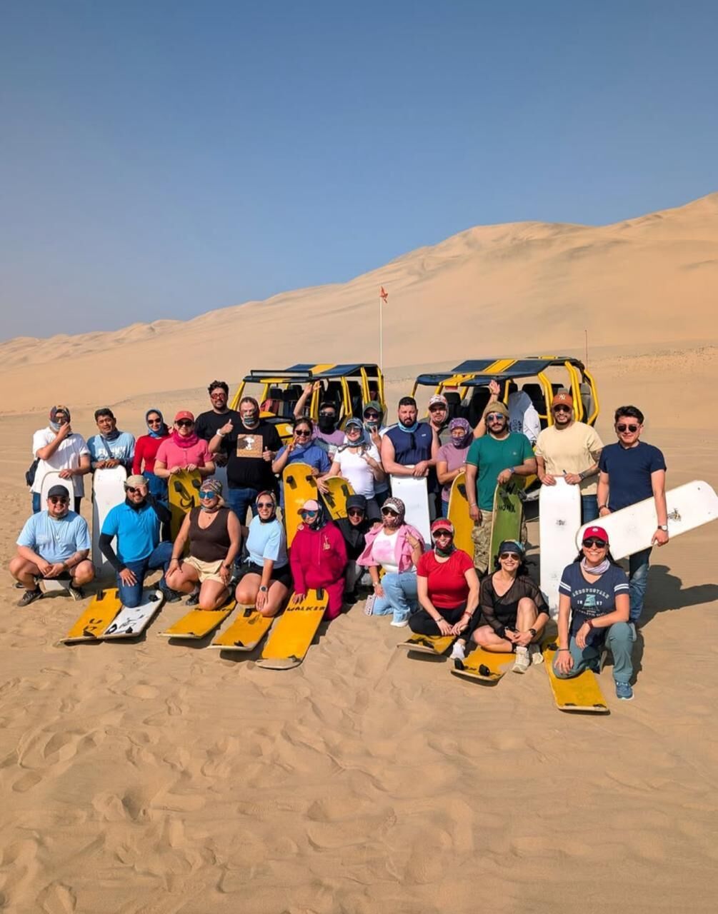 A group of people with surfboards in a desert setting.