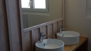 A bathroom with two round white sinks, a wooden vanity, and a mirror with lights. - B&B with breakfast (Lège-Cap-Ferret)