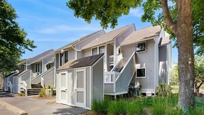 Une rangée de bâtiments d’un seul étage, à la façade blanche, avec des porches et des escaliers menant à l’entrée.