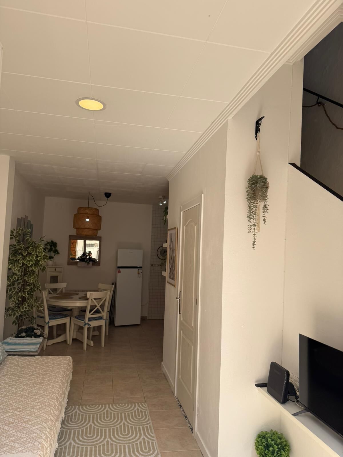 Ein kompakter Wohnbereich mit Essplatz, Küchenzeile und einem an der Wand befestigten Fernseher.