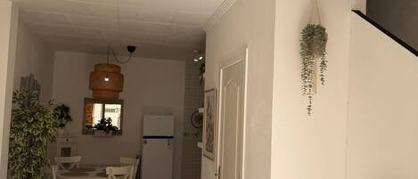 Ein kompakter Wohnbereich mit Essplatz, Küchenzeile und einem an der Wand befestigten Fernseher.