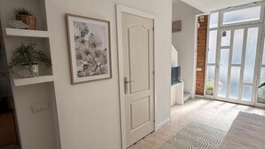 A spacious room with a large window, a door, and a tiled floor.