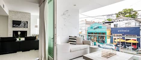 A modern living room with a sofa, a coffee table, and a view of the street.
