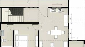 Plànol d'una habitació d'hotel amb un llit, una escriptori, una cadira, una taula petita, un sofà i un bany.