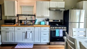 A kitchen with white cabinets, a stainless steel oven, a microwave, and a toaster. - Historic Charm Meets Modern Comfort - Minutes to San Antonio Downtown/Riverwalk (San Antonio)