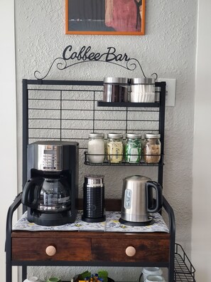 A coffee bar setup with a Mr. Coffee machine, a kettle, and storage shelves. - Historic Charm Meets Modern Comfort - Minutes to San Antonio Downtown/Riverwalk (San Antonio)