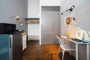 A compact kitchen with a refrigerator, microwave, and wooden flooring. - The Jewelry · The Boutique Favorite (Bang Rak)