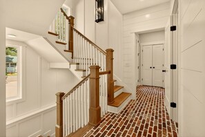 Una escalera con barandilla de madera y suelo de ladrillo.