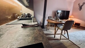 Et moderne køkken med spiseplads, fjernsyn og pejs.