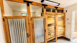 A room with a sliding wooden door, a radiator, and a wall-mounted light fixture. - Ponderosa Pines Resort (Parks)