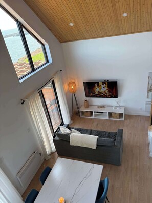 Una sala de estar moderna con un sofá, televisor y una mesa.