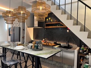 A modern kitchen with a marble countertop, stainless steel appliances, and a black backsplash. - 10 min BTS 1Gbs WIFI NFLIX Full Kitchen HomeCinema (Khet Phra Khanong)