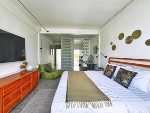 A bedroom with a bed, a dresser, a green bean bag chair, a desk, and a chair. - 10 min BTS 1Gbs WIFI NFLIX Full Kitchen HomeCinema (Khet Phra Khanong)