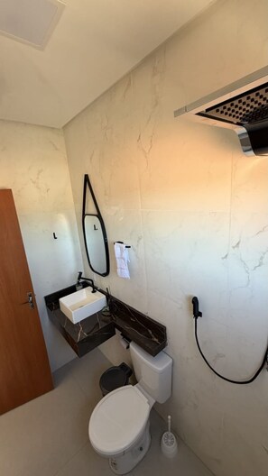 Un baño pequeño con inodoro, lavamanos y espejo.