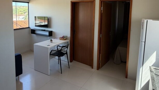 Uma cozinha moderna com uma geladeira branca, uma porta de madeira e uma janela.