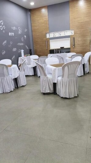 A conference room with white chairs and tables, a wooden wall, and a whiteboard. - Hotel Balneário (Angra dos Reis)