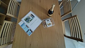A wooden table with a bottle of champagne, a brochure, and a container of almonds. - In the shade of a beech tree: An oasis of tranquility just a few minutes from the lake (Miasino)
