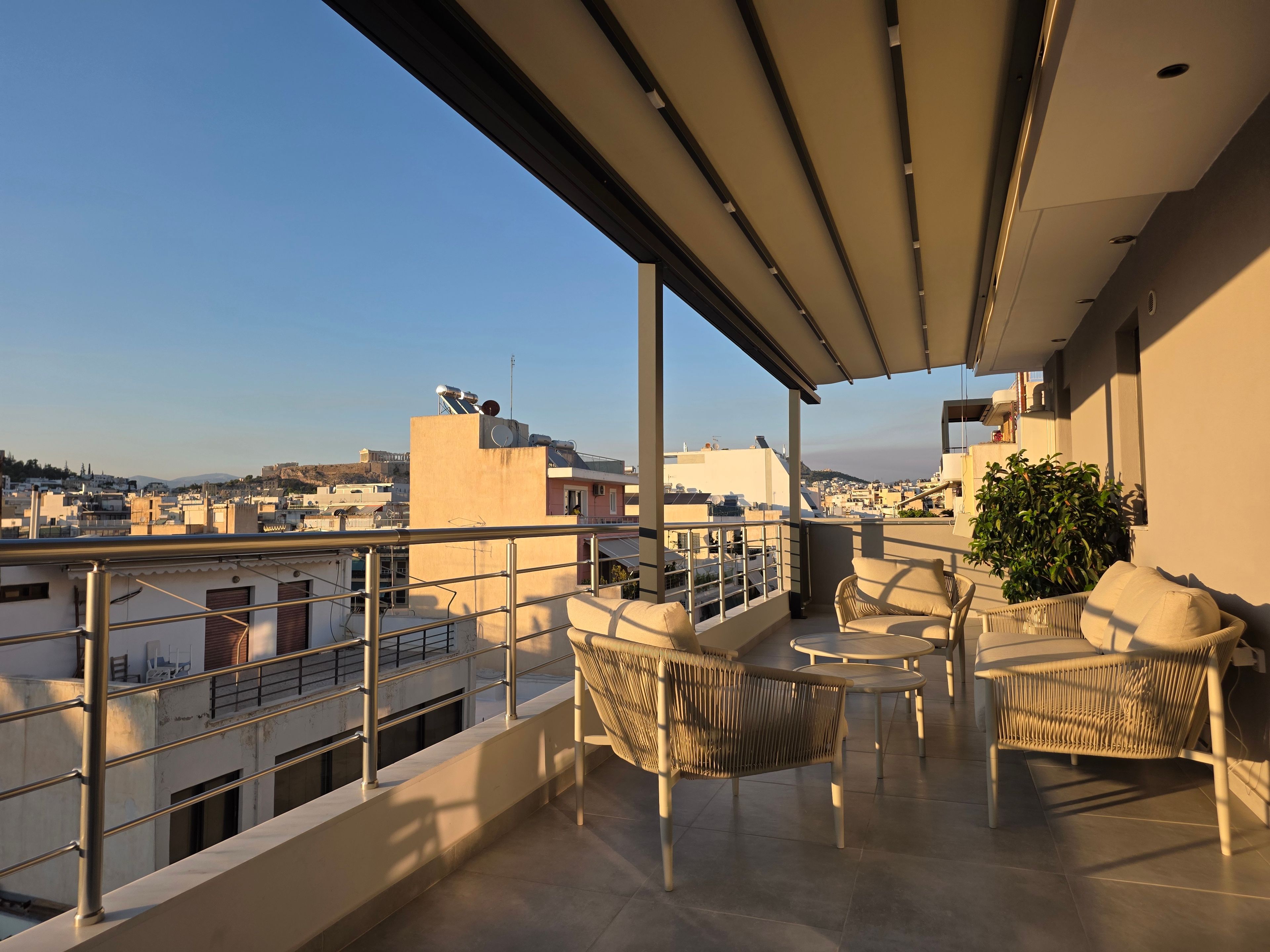 Ein Balkon mit Blick auf die Stadtlandschaft, einschließlich Gebäude und eines Hügels.