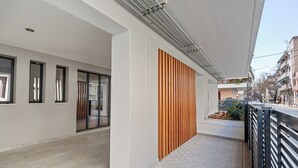 A modern building with large windows, a wooden slat wall, and a tiled floor. - Athens Vein (Athens)