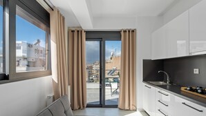 A modern kitchen with a black countertop, a sink, and a window with curtains. - Athens Vein (Athens)