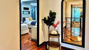 Une chambre d’hôtel avec un lit, une table de chevet et un miroir qui reflète la pièce.