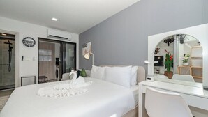 A modern hotel room with a large bed, a desk, a mirror, and a shower area. - Comfy 1BR Getaway by Beach & Shops- diamond C176 (Tambon Choeng Thale)