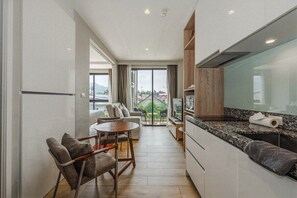 Cozinha moderna com área de refeições, janelas amplas e vista para o exterior.