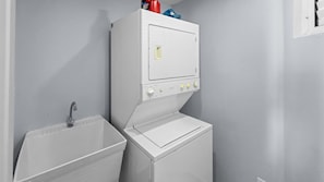 A compact laundry area with a washing machine and a sink. - Hillside Village Hideaway | Sleeps 8 Comfortably (Mameyes II)