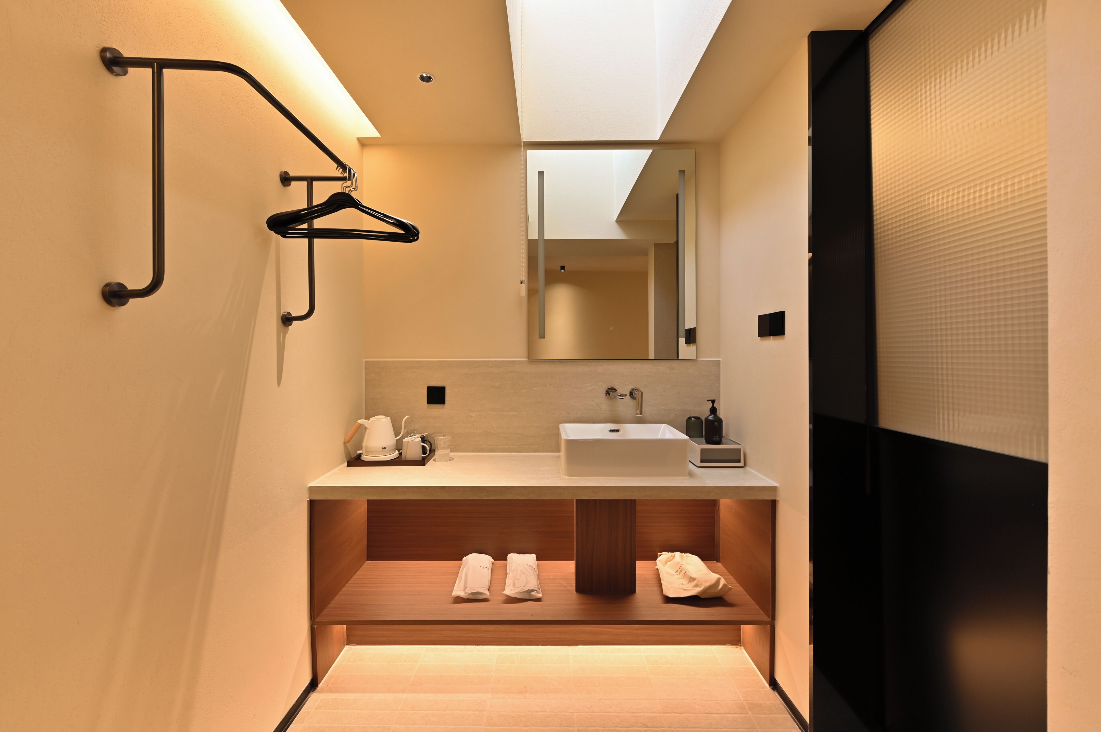 A modern bathroom with a built-in sink, towel rack, and mirror.