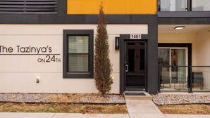 A building with a sign reading 'The Tazinya's ON 24TH' and a door labeled '1401'. - H3 Spacious & Urban Modern Condo - Great Location! (Oklahoma City)