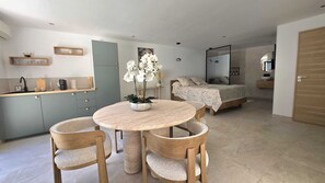 Un appartement moderne comprenant une cuisine, un coin repas et une chambre.