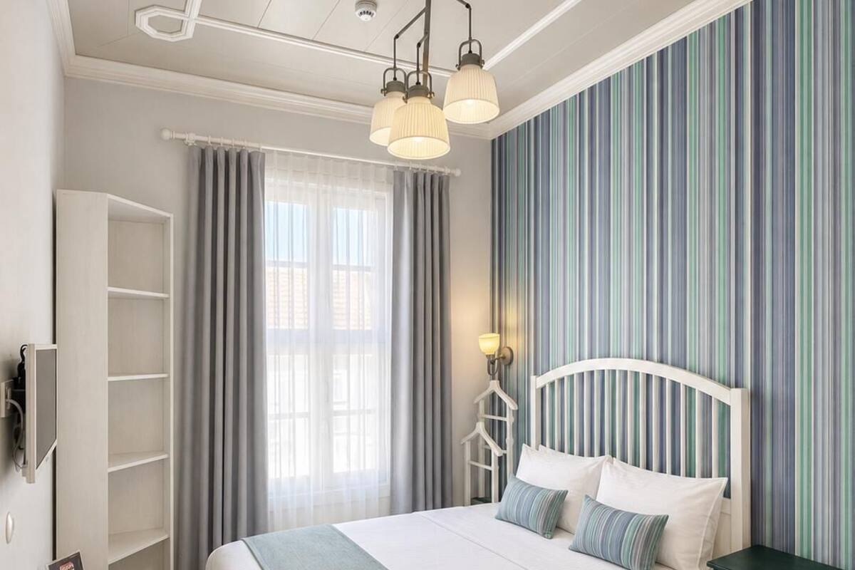 Un dormitorio ordenado con cama, mesita de noche y armario.