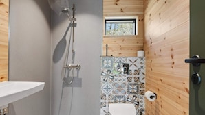 A small bathroom with a shower, toilet, and sink. - 4 Star Holiday Home in Hasle (Hasle)