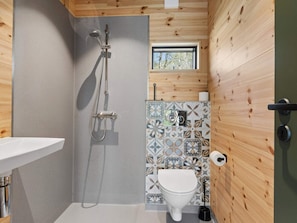 Ein kleines Badezimmer mit Dusche, Toilette und Waschbecken.