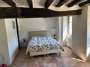 A bedroom with a bed, two bedside tables, a window, and exposed wooden beams. - 2 country houses, sleeps 8, swimming pool (Saint-Denis-d'Anjou)
